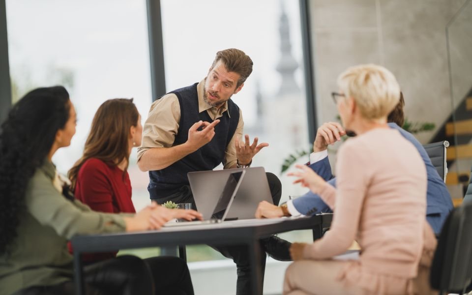 V6 Cube colleagues discussing a project around a meeting table