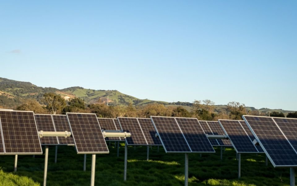 Rows of solar panels in a green valley