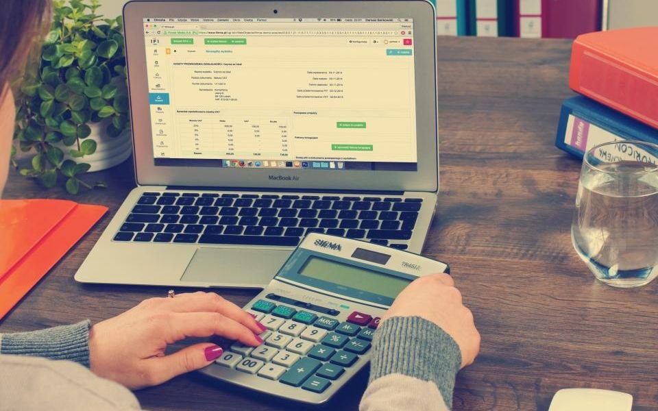 Budgeting a project with a laptop spreadsheet and a calculator, from our guide to software project planning