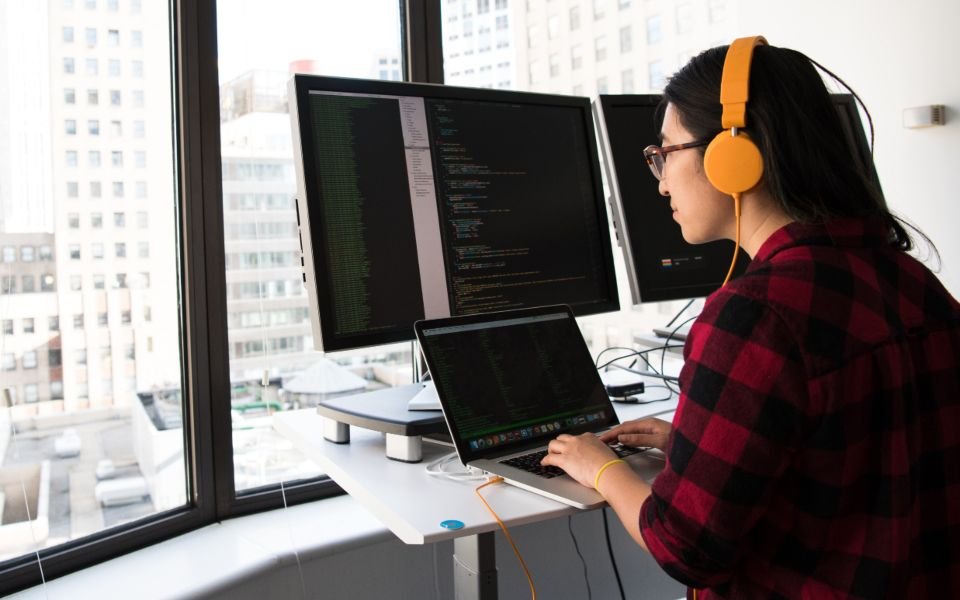 A developer building the first version of a product at a desk with two monitors